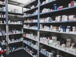 A person comparing medication boxes and bottles while reading drug labels at home.
