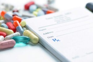 Assorted colorful pills and capsules arranged on a plain white surface.